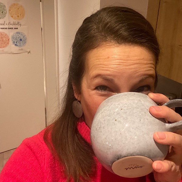 Frau trinkt aus grauer Tasse