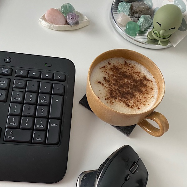 Tasse Kaffee mit Tastatur, Maus und Edelsteinen